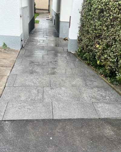 Neu verlegter Gehweg mit grauen Pflasterplatten im Eingangsbereich durch professionellen Galabau