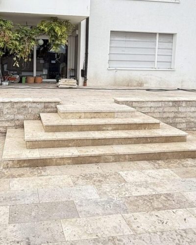 Hochwertige Naturstein-Terrasse mit Treppenanlage und Stützmauer durch professionellen Galabau