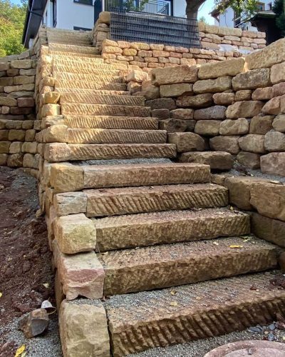 Natursteintreppe mit Trockenmauer und Hangbefestigung aus Naturstein durch professionellen Galabau