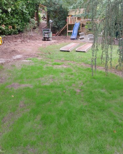 Neu angelegte Rasenfläche im Garten mit Galabau-Arbeiten und Spielbereich