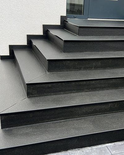 Moderne schwarze Granittreppe am Hauseingang mit professionellem Treppenbau durch Galabau