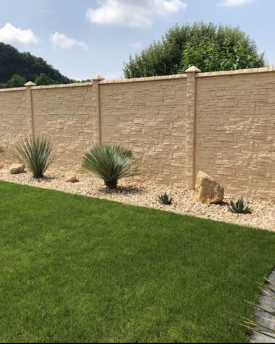 Moderne Sichtschutzmauer im Garten mit Rasenfläche, Kiesbeet und professioneller Galabau-Gartengestaltung