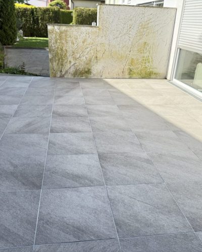 Moderne Terrasse mit grauen Terrassenplatten und professioneller Verlegung durch Galabau